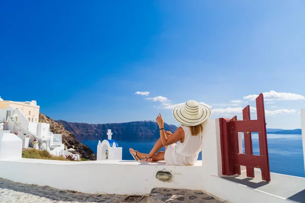 Luxe reizen vakantie vrouw kijkt aan uitzicht op Santorini eiland — Stockfoto