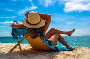 Bir kadın, tropikal plajda tatilin tadını çıkarıyor. 