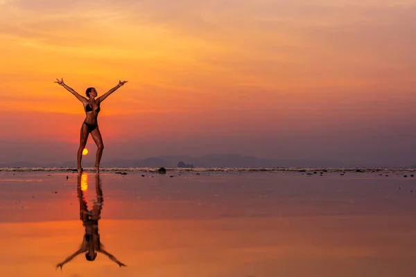 Žena na pláži při západu slunce — Stock fotografie