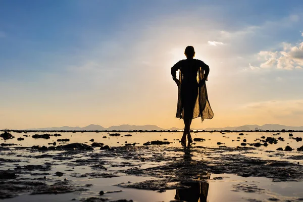 Kvinna på stranden vid solnedgången — Stockfoto