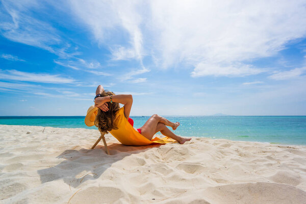 Женщина наслаждается отдыхом на трансате на тропическом пляже
 