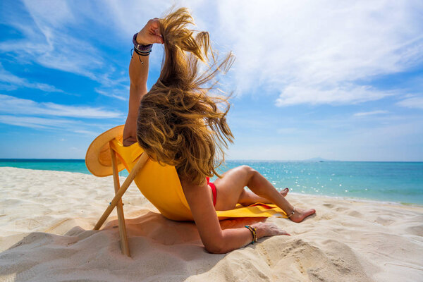 Женщина наслаждается отдыхом на трансате на тропическом пляже
 