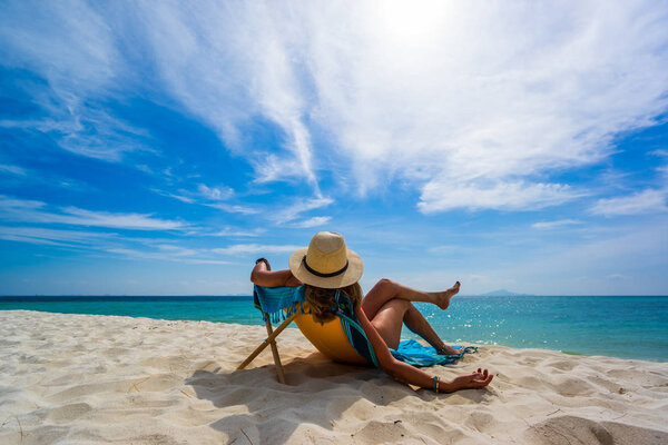 Женщина наслаждается отдыхом на трансате на тропическом пляже
 