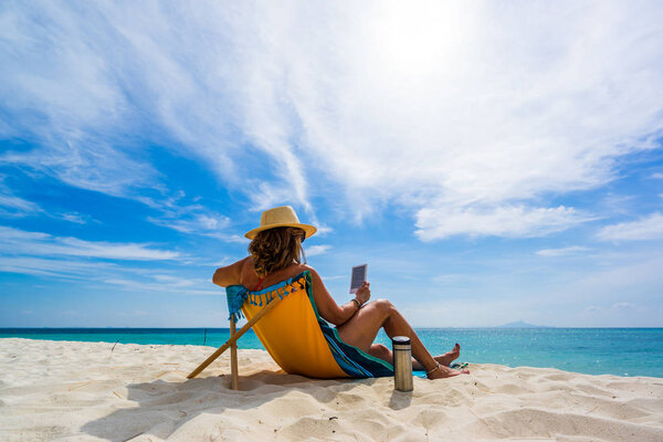 Женщина наслаждается отдыхом на трансате на тропическом пляже
 