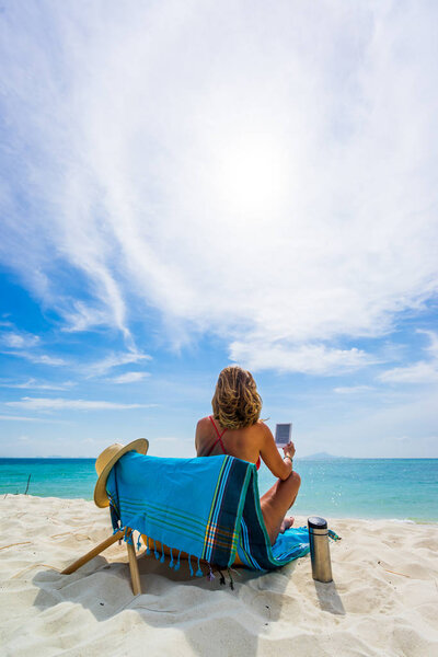 Женщина наслаждается отдыхом на трансате на тропическом пляже
 