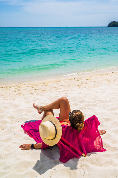 Женщина наслаждается отдыхом на трансате на тропическом пляже
 