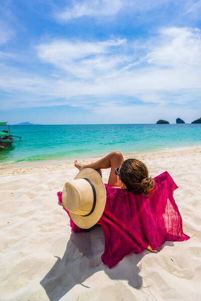 Женщина наслаждается отдыхом на трансате на тропическом пляже
 