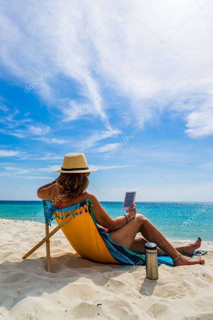 Woman enjoying her holidays on a transat at the tropical beach 