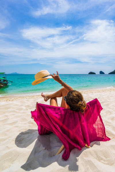 Женщина наслаждается отдыхом на трансате на тропическом пляже
 