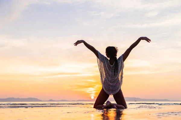 Vrouw op het strand bij zonsondergang — Stockfoto