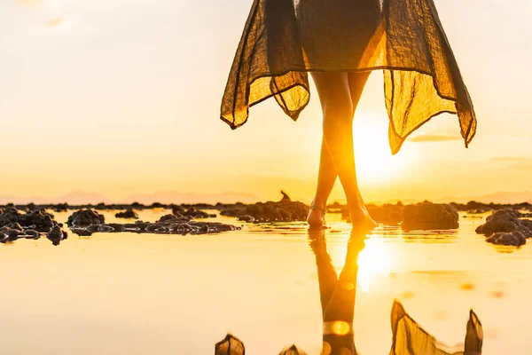 Kvinna på stranden vid solnedgången — Stockfoto