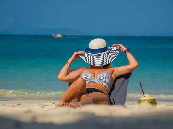 Женщина наслаждается отдыхом на трансате на тропическом пляже
 