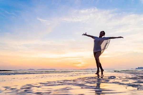 Vrouw op het strand bij zonsondergang — Stockfoto