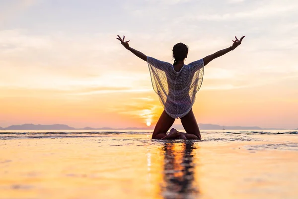 Vrouw op het strand bij zonsondergang — Stockfoto