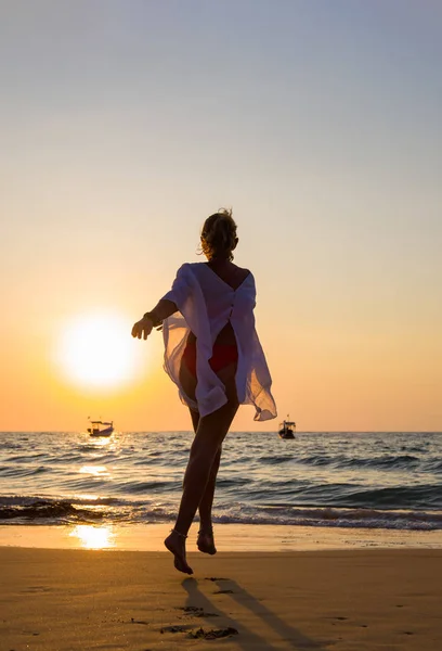 Frau, die am Strand spazieren geht — Stockfoto