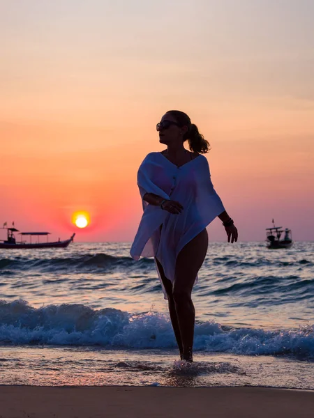 Mujer caminando en la playa a —  Fotos de Stock