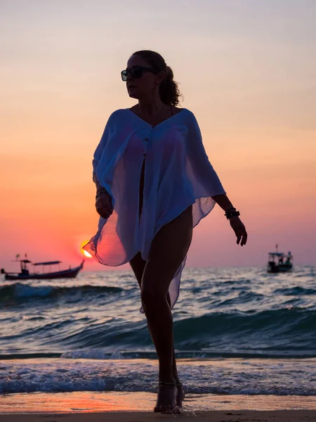 Frau, die am Strand spazieren geht — Stockfoto