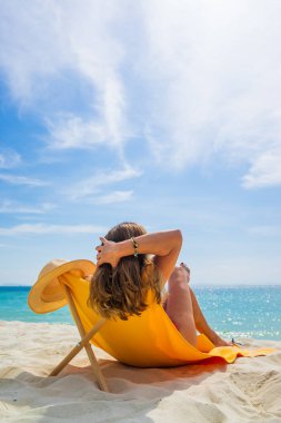 Bir kadın, tropikal plajda tatilin tadını çıkarıyor. 