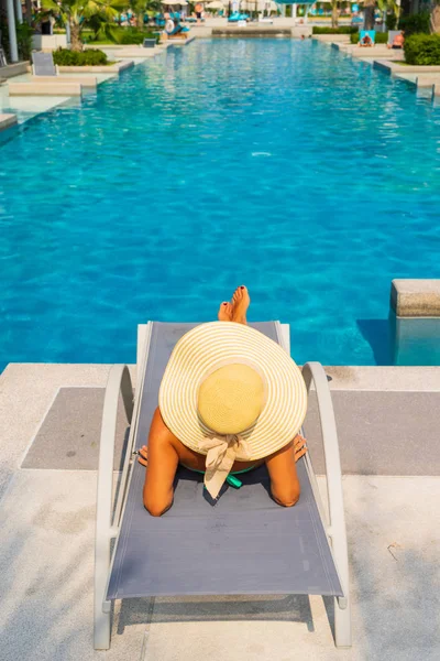 Donna che si rilassa in piscina nel resort di lusso — Foto Stock