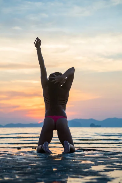 Vrouw op het strand bij zonsondergang — Stockfoto