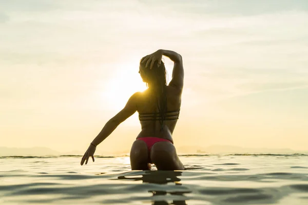Kvinna på stranden vid solnedgången — Stockfoto