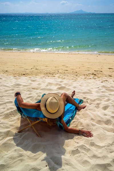 女性楽しみます彼女の休日上のトランザクションで熱帯のビーチ — ストック写真