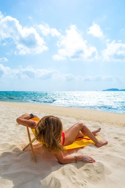 女性楽しみます彼女の休日上のトランザクションで熱帯のビーチ — ストック写真
