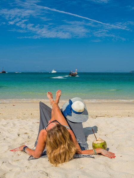 Женщина наслаждается отдыхом на трансате на тропическом пляже
 