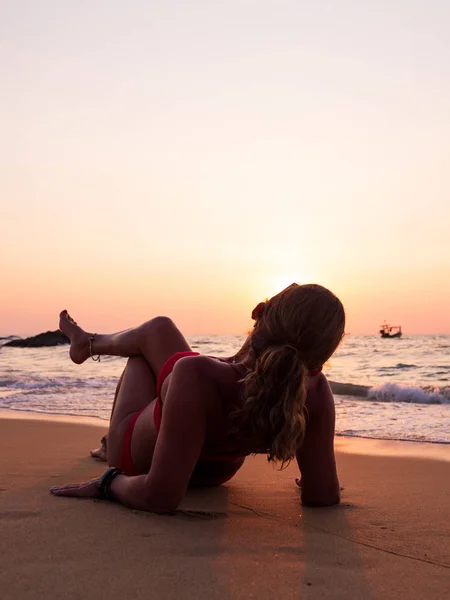 Jonge vrouw op de zee bij zonsondergang — Stockfoto