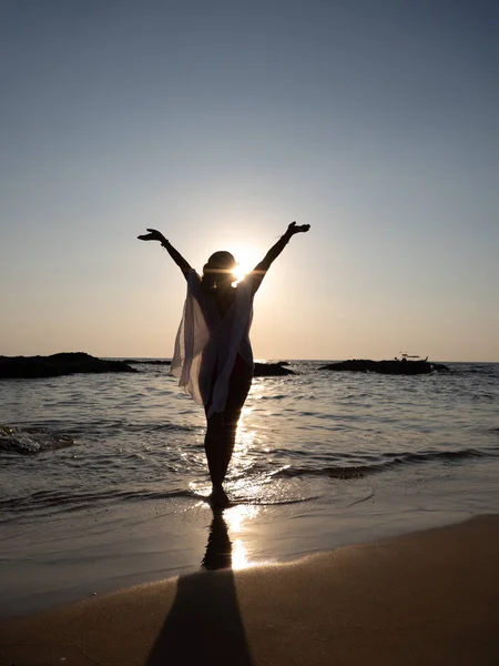 Gün batımında denizde yürüyen genç bir kadın. — Stok fotoğraf