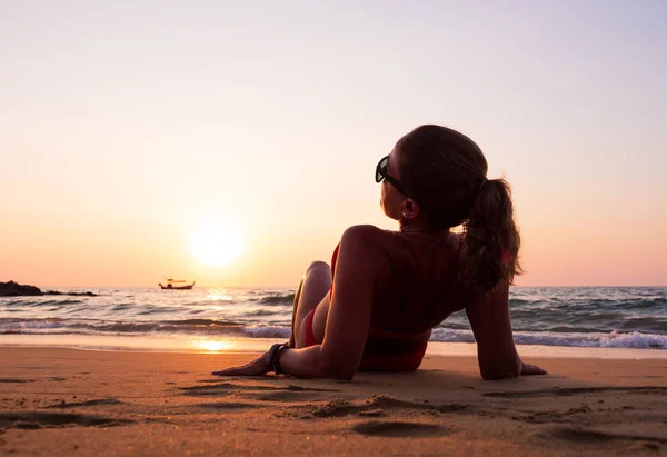 Jonge vrouw op de zee bij zonsondergang — Stockfoto