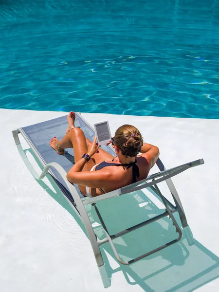 Frau im Schwimmbad liest — Stockfoto