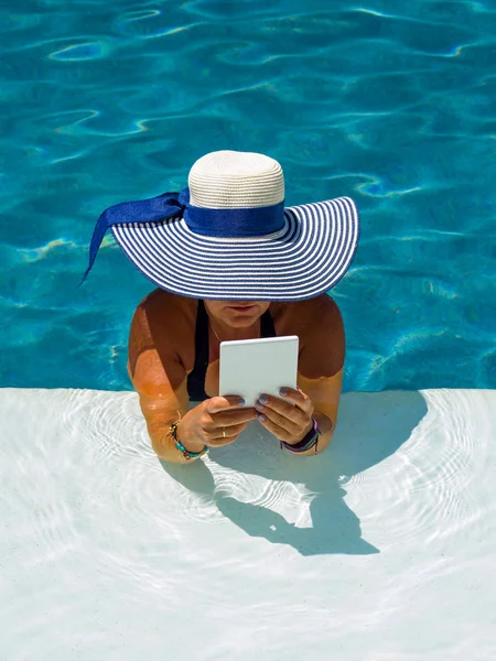 Woman at the swimming pool reading — Stock Photo, Image