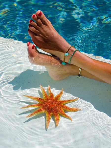 Ženské nohy s hvězdicí u bazénu — Stock fotografie