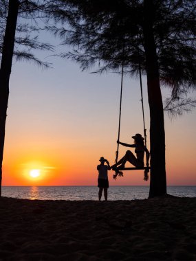 Genç bir çift sahilde fotoğraf çekiyor. 