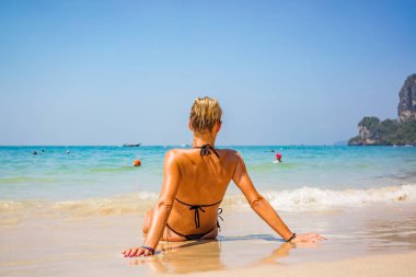 Kadın, tropik plajda tatilin tadını çıkarıyor.