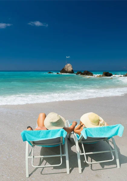 Ζευγάρι σε ξαπλώστρες χαλαρώνοντας στην παραλία της Λευκάδας — Φωτογραφία Αρχείου