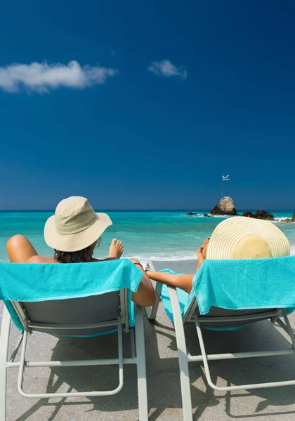 Paar op ligbedden ontspannen aan het strand in Lefkada — Stockfoto