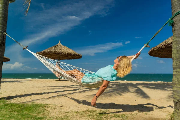 Mujer sentada en una hamaca en la playa . —  Fotos de Stock