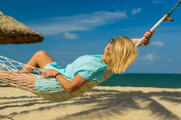 Donna seduta in amaca sulla spiaggia . — Foto Stock