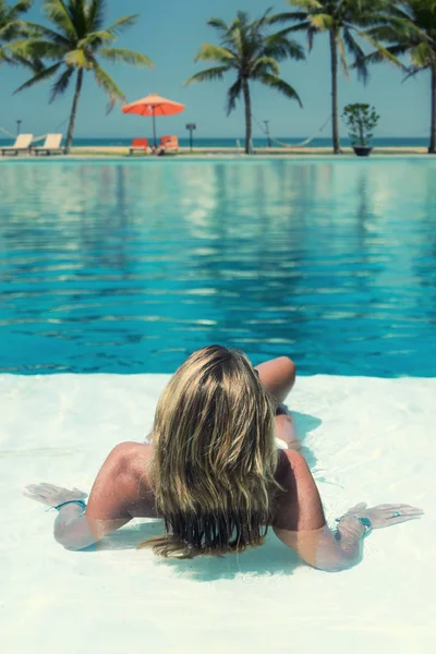 Mooie vrouw ontspannen in een zwembad in de zomer — Stockfoto