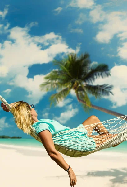 Vrouw zitten in een hangmat op het strand. — Stockfoto