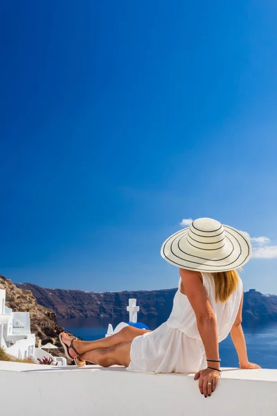 Luxe reizen vakantie vrouw kijkt aan uitzicht op Santorini eiland — Stockfoto