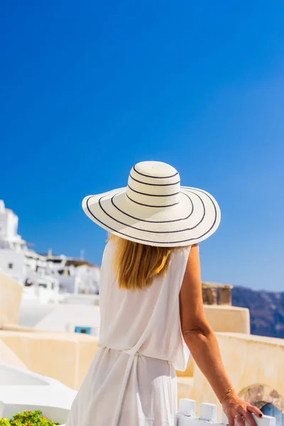 Luxe reizen vakantie vrouw kijkt aan uitzicht op Santorini eiland — Stockfoto