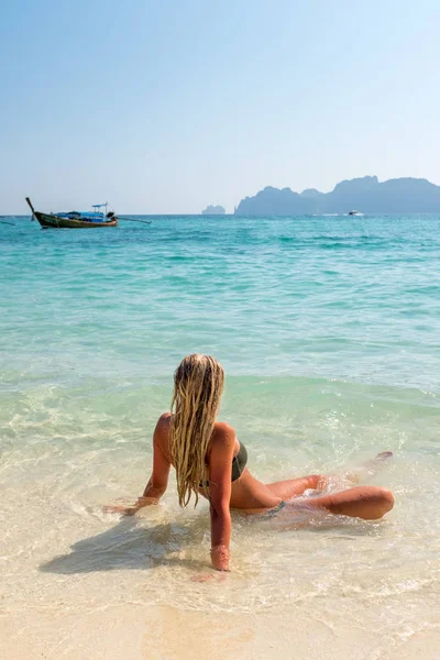 Mujer tomando el sol sentada en la playa tropical —  Fotos de Stock