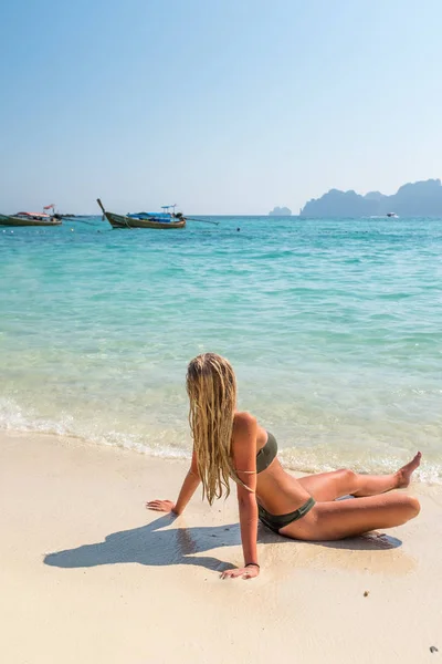 Femme bronzant assise sur la plage tropicale — Photo