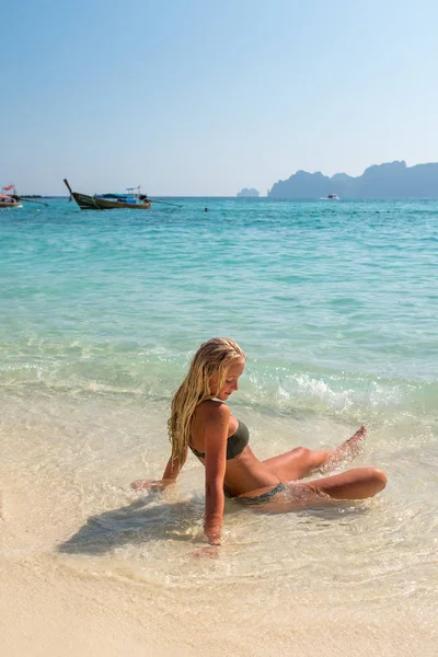 女人坐在热带海滩上晒日光浴 — 图库照片