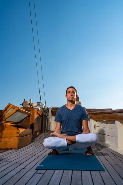 Man practicing Yoga on a sailing yacht — Stock Photo, Image