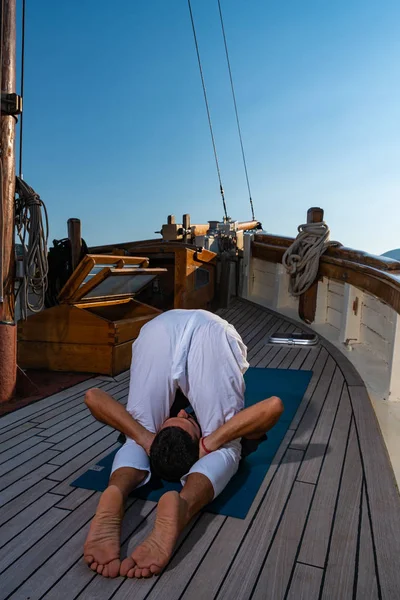 ヨガをヨットで練習する男 — ストック写真