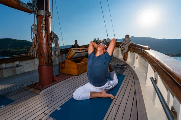 Man praktiserar Yoga på en segelbåt — Stockfoto